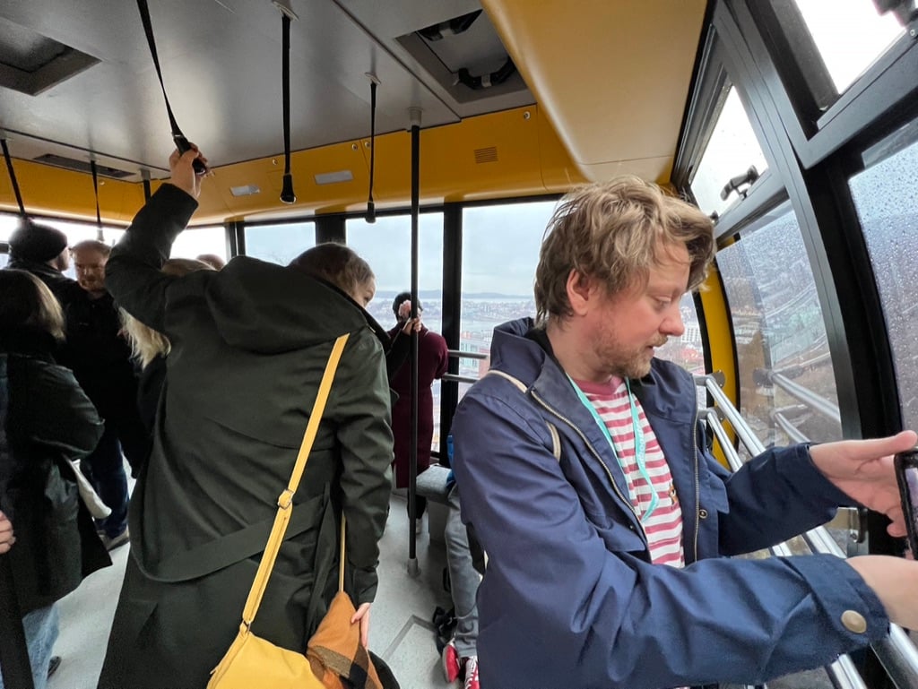 En mengde folk inni gondolvognen Bruse, hvorav én fotograferer nedover i vognens fartsretning